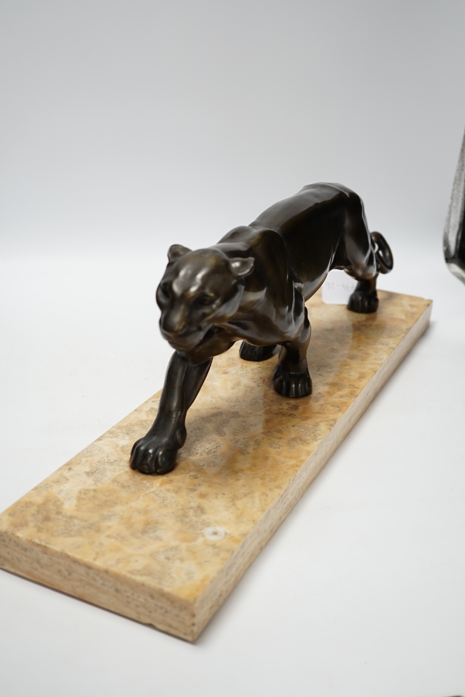 A French Art Deco bronzed metal model of a panther on a marble base, base 55cm wide